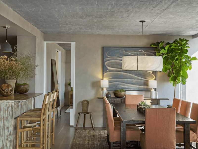 Dining room area with a table surrounded by chairs and high bar chairs at an island