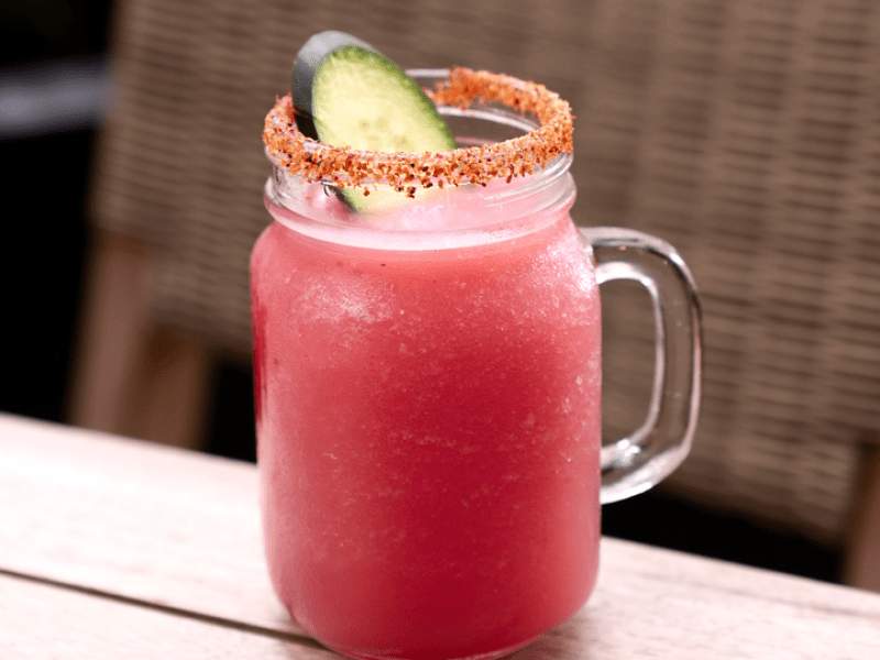 Pink cocktail in a mason jar with a salt rim