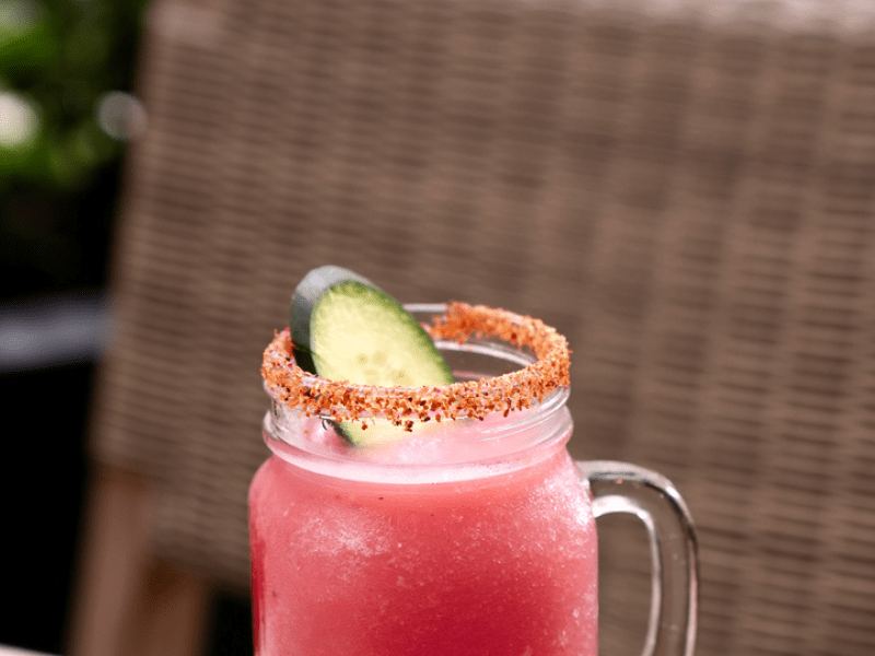 Pink cocktail in a mason jar with a salt rim