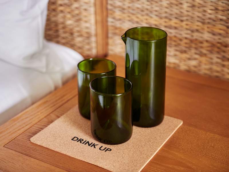 Three green glasses on a cork coaster