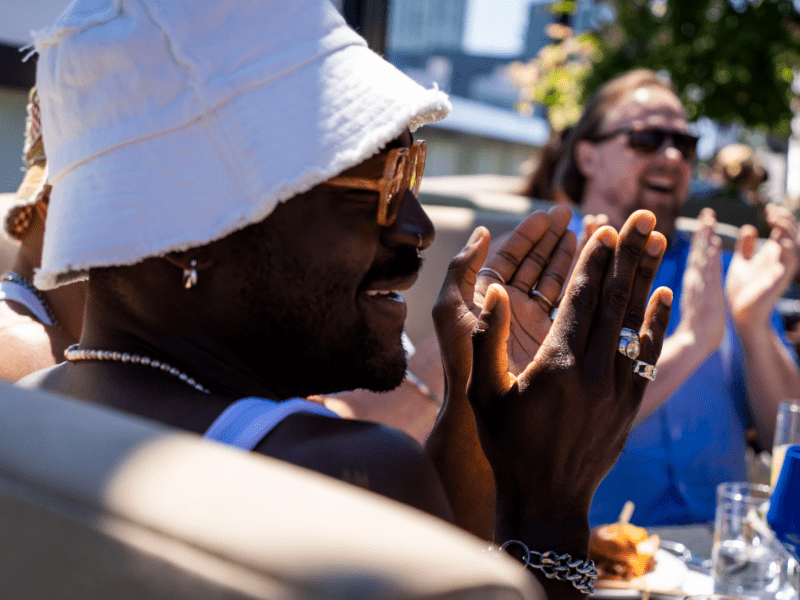 Person wearing a bucket hat clapping