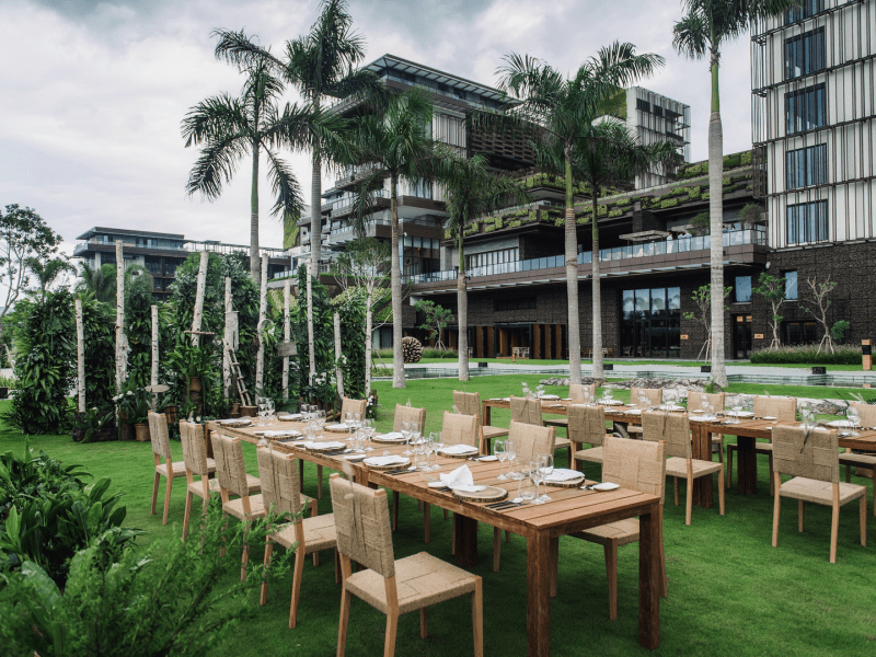 Dining tables set outdoors in a grassy field