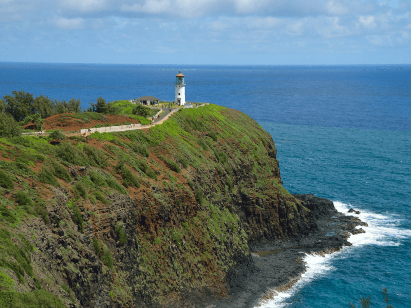 A far-off view of a lighthouse atop a cliff