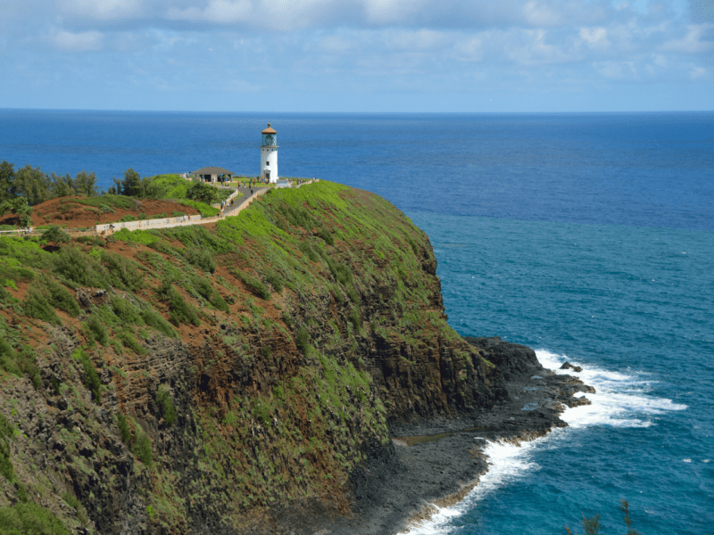 A far-off view of a lighthouse atop a cliff