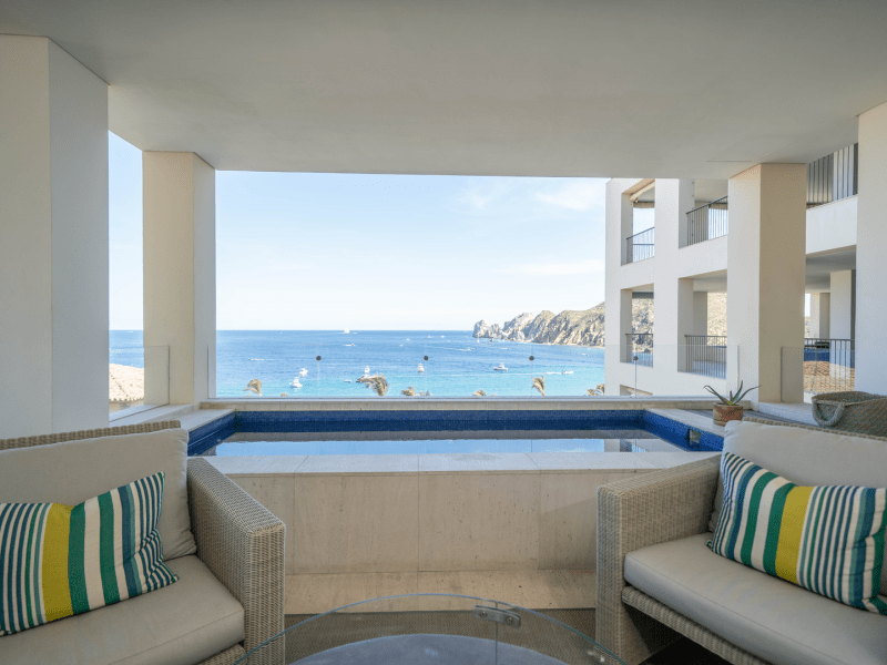 A view out to the ocean from a room with a pool