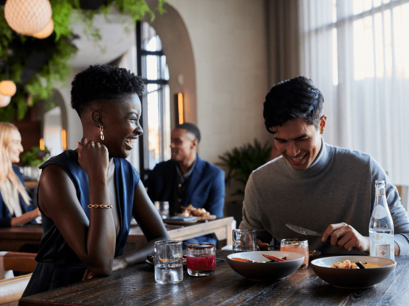 People in a restaurant laughing while eating dinner