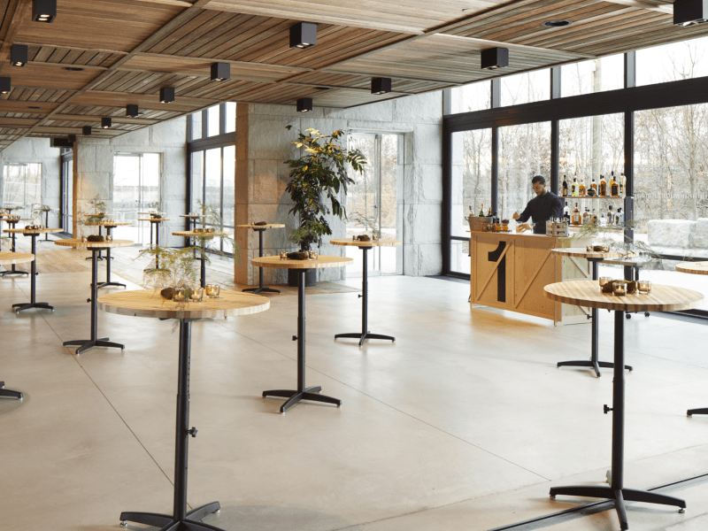 Room filled with tall windows and tall round small tables