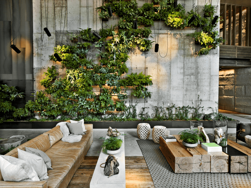 Green plant life decorates a stone wall in the 1H Brooklyn Bridge lobby