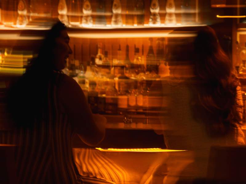 two people at night sitting at bar