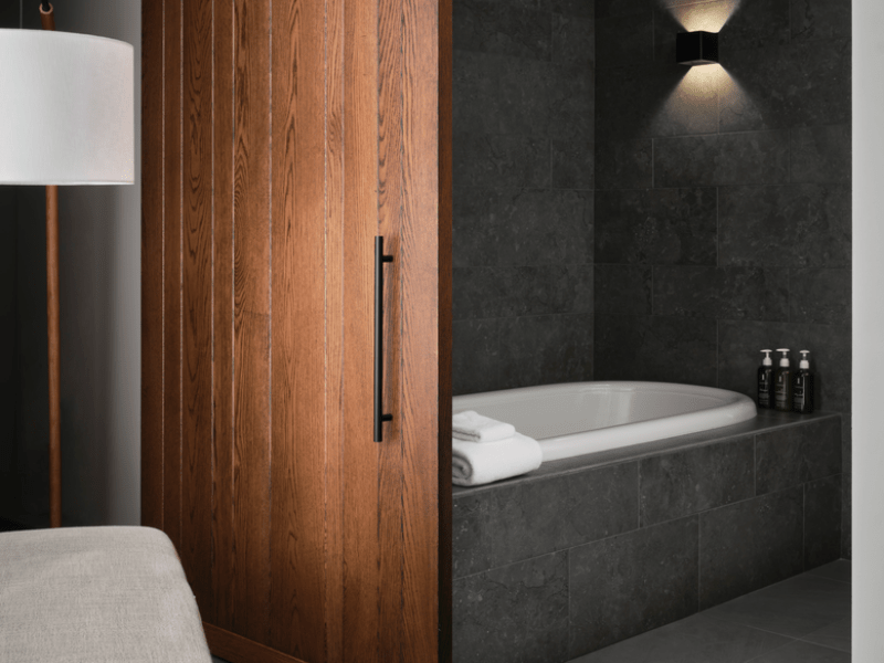 Dark themed bathroom with a sliding door to the bathtub