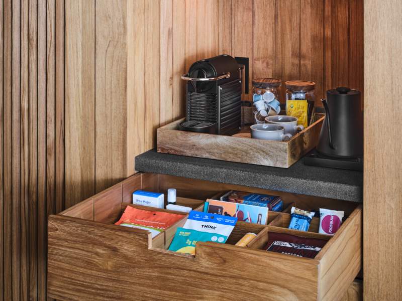 In room bar with nespresso machine and drawer full of snacks