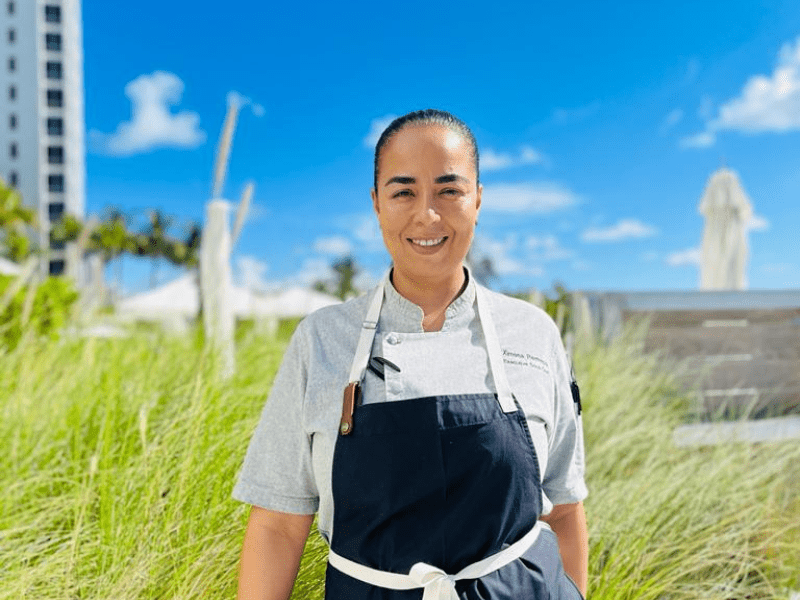 Chef posing for a photo in front of tall grass