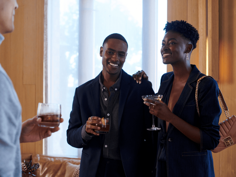 People holding a drink and laughing