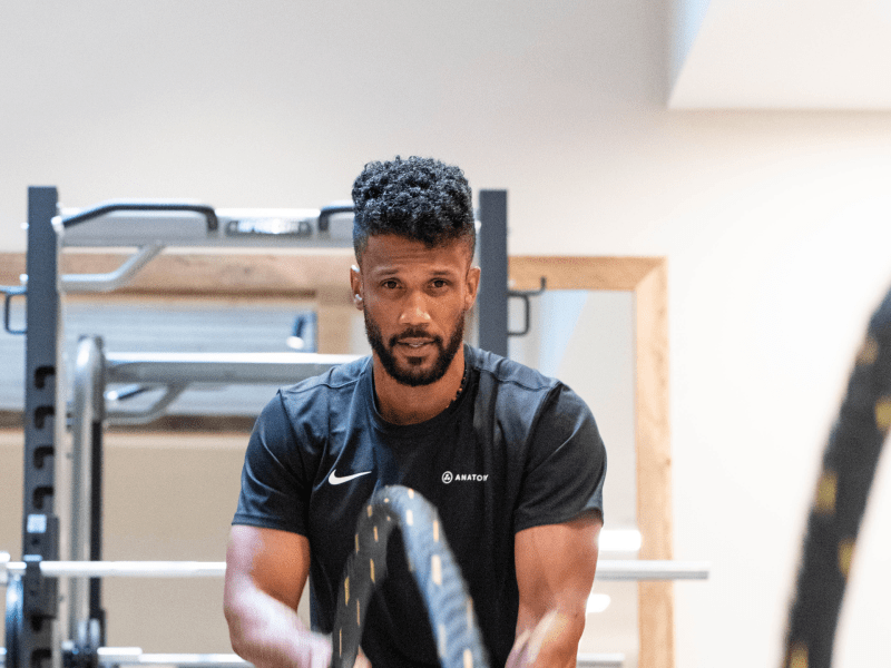 Trainer at Anatomy using Battle Ropes to train