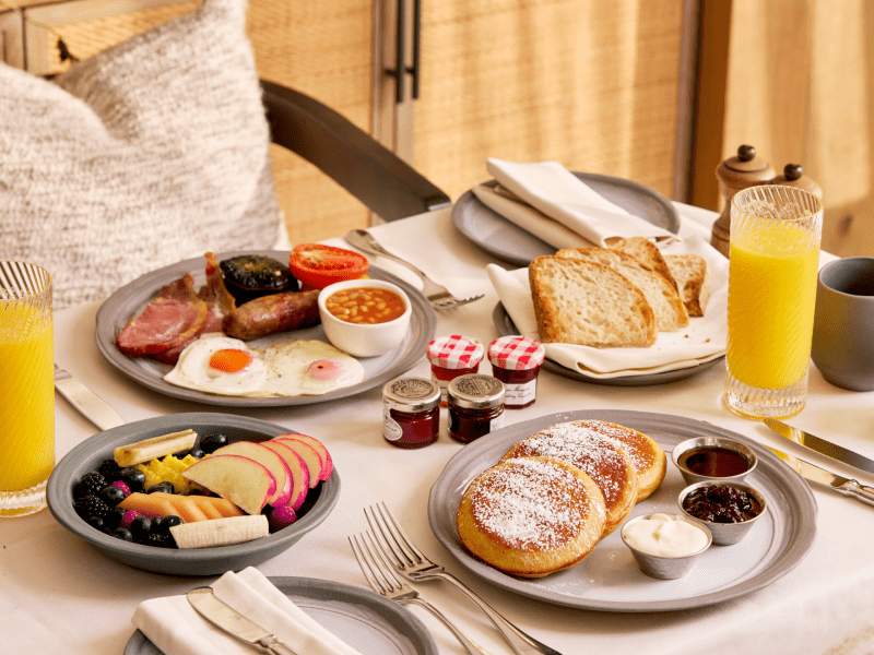 A spread of breakfast dishes in a warmly lit hotel room