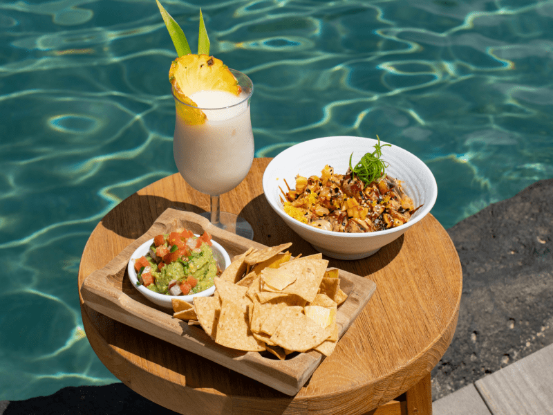 Poke bowl, chips and dip and a pina colada by the poolside
