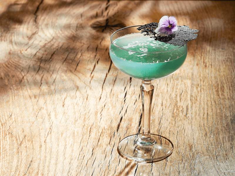 Green cocktail with a flower on the rim