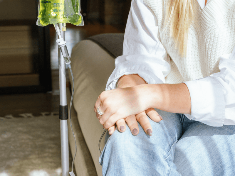 Person sitting cross-legged getting an IV infusion