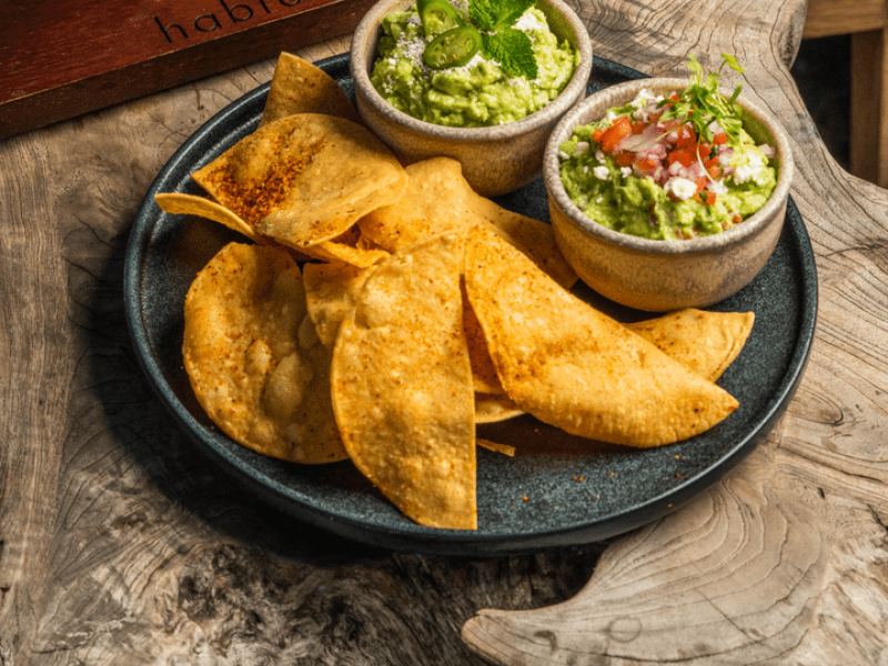 Chips with guacamole dip and a drink