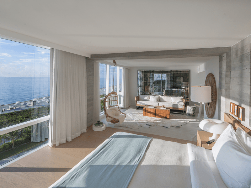 Presidential Suite for 1 Hotel South Beach complete with panoramic views of the water and a fully furnished living room area adjacent to the king size bed