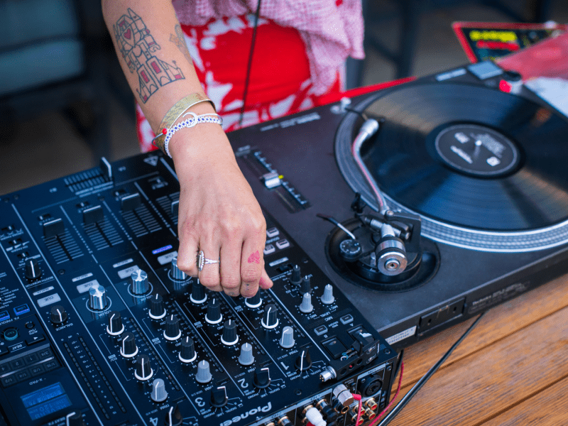 A DJ tuning his mixers controls