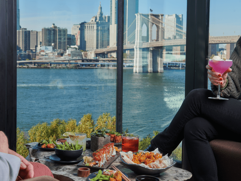 food spread alongside view of Brooklyn Bridge 