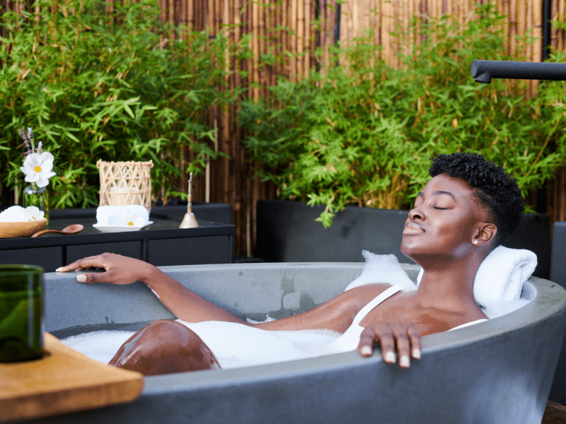 Woman relaxing in a tub on spa terrace