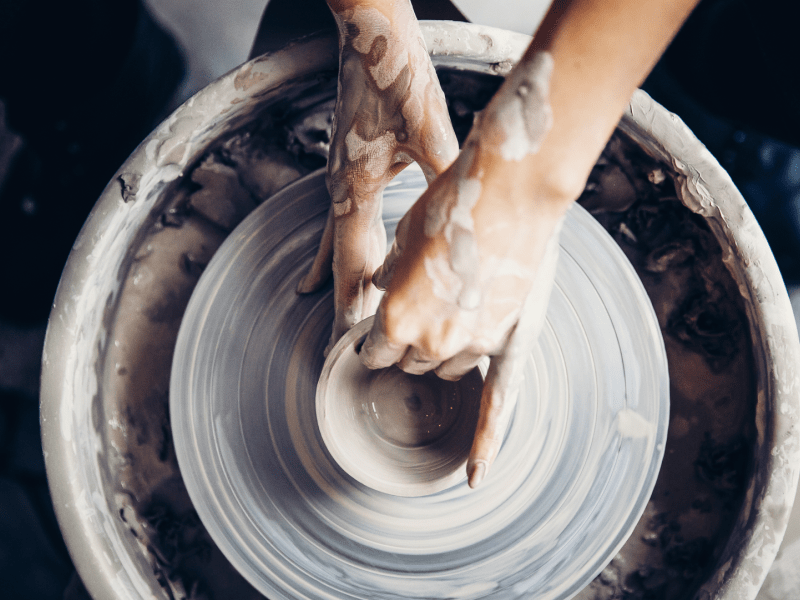 hands shaping pottery on a pottery wheel
