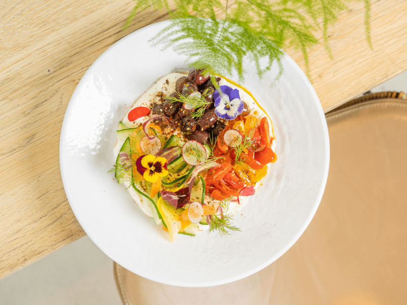 A plate with cooked vegetables and flower garnish
