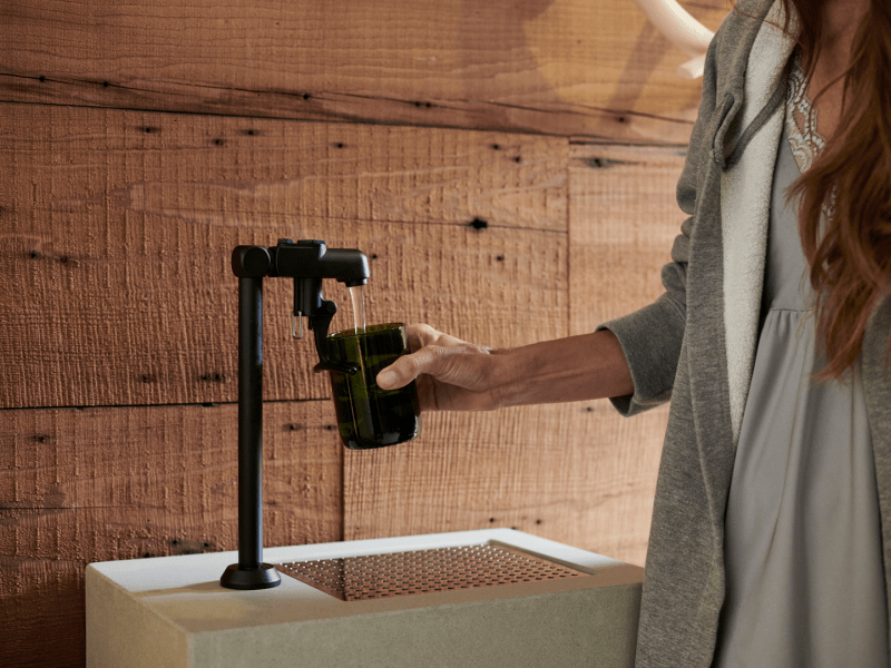 Person filling a glass at a water fountain