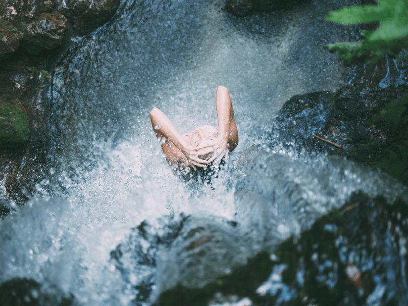 Woman standing in waterfall