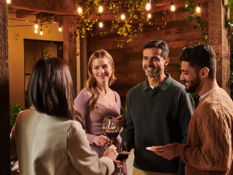 a group of people talking and drinking wine