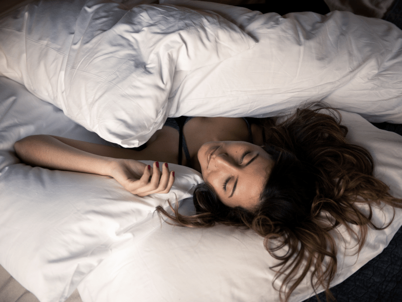 Person with messy hair laying in a bed