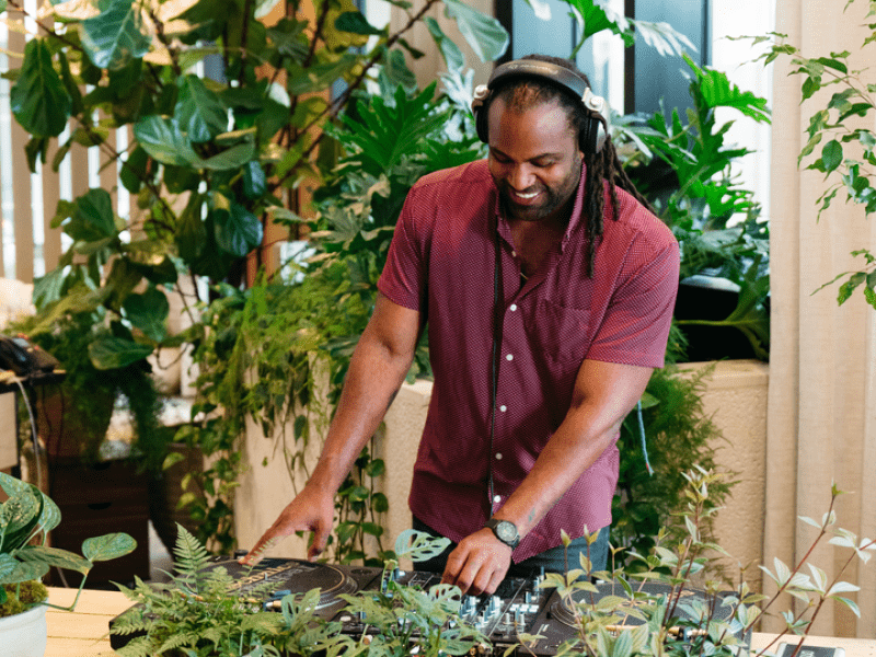 Person using a turntable with plants next to it