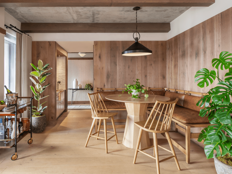 Wood paneled dining room with a bench, table and chairs