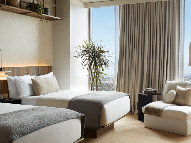 Two beds side by side with views of the city 