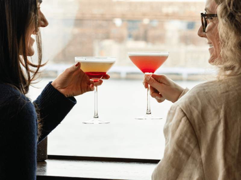 two women admiring the view with a cocktail