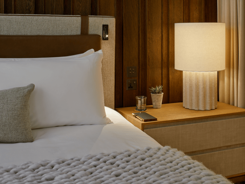 Bedside table with a lamp and potted plant