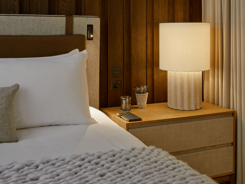 Bedside table with a lamp and potted plant