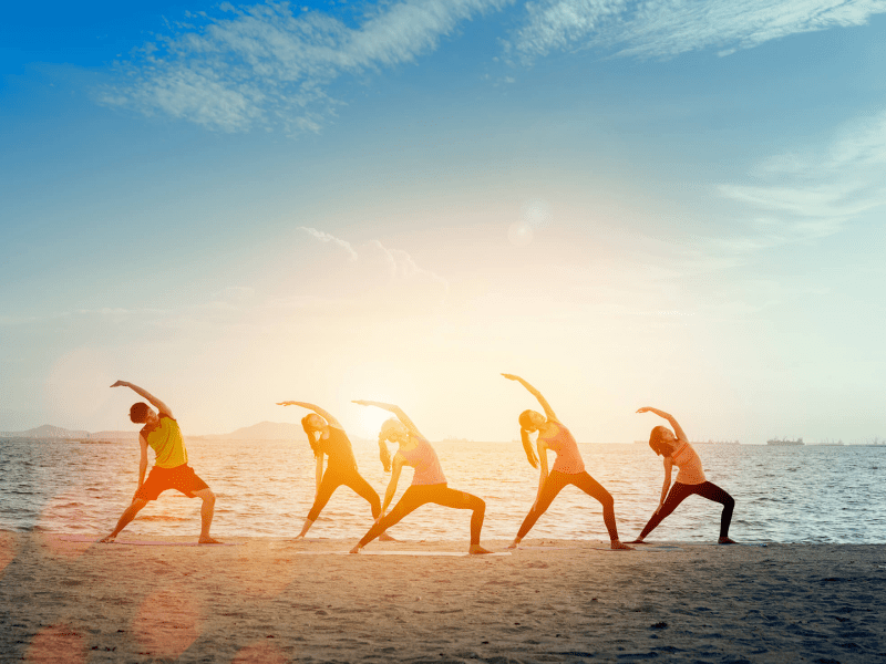 A group of people doing yoga on a beach