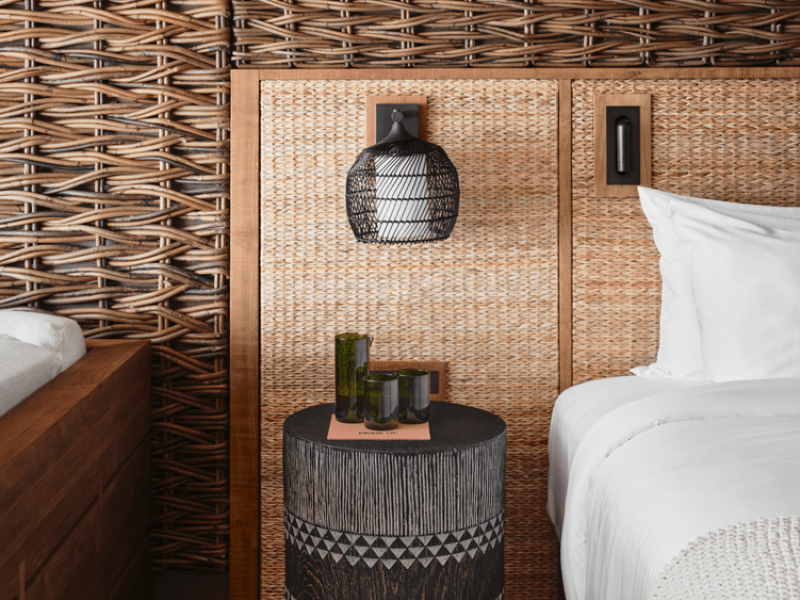 A decorative side table sits in front of a rustic wooden backdrop