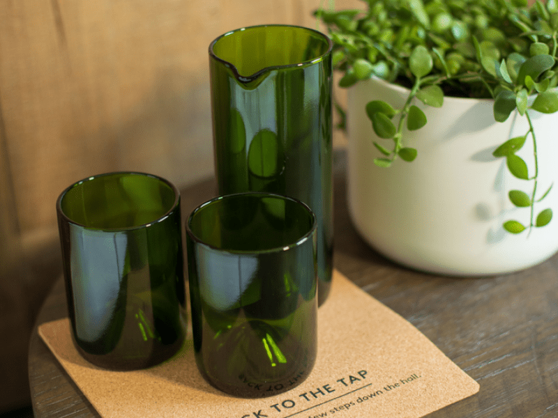 Three green glasses on a cork coaster