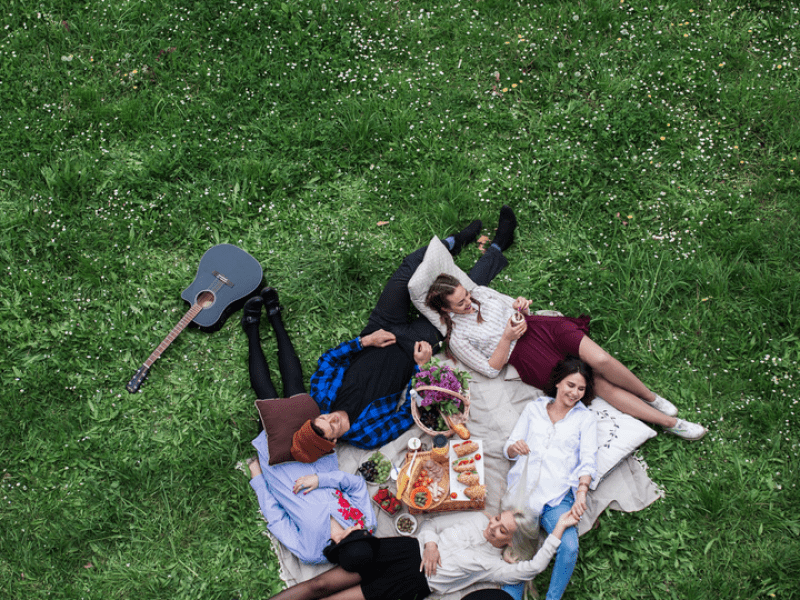 Group of people lying on the ground together at a picnic