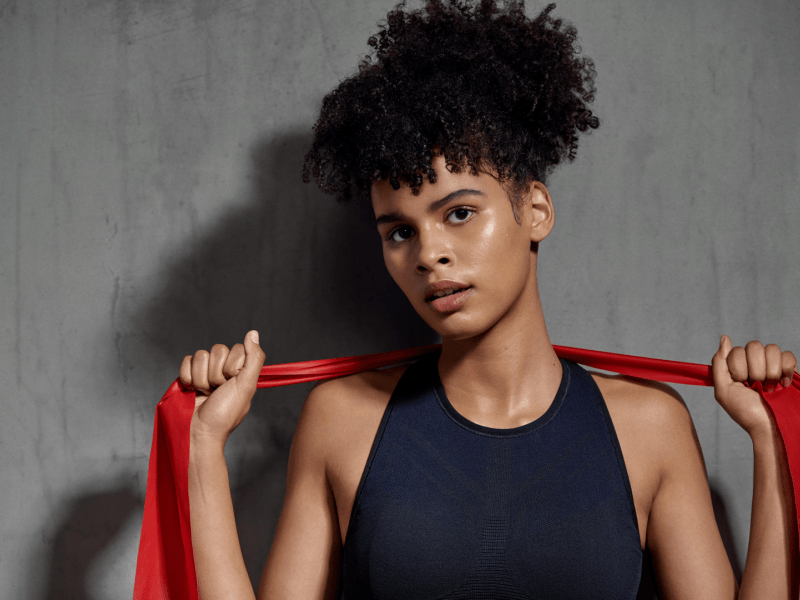 Woman stretching exercise band behind her shoulders 