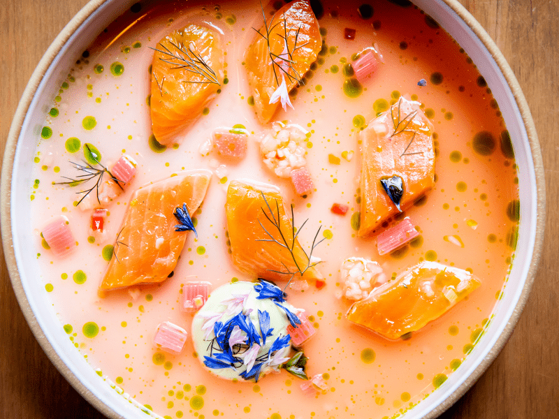 A colourful dish of trout crudo, in a creamy broth