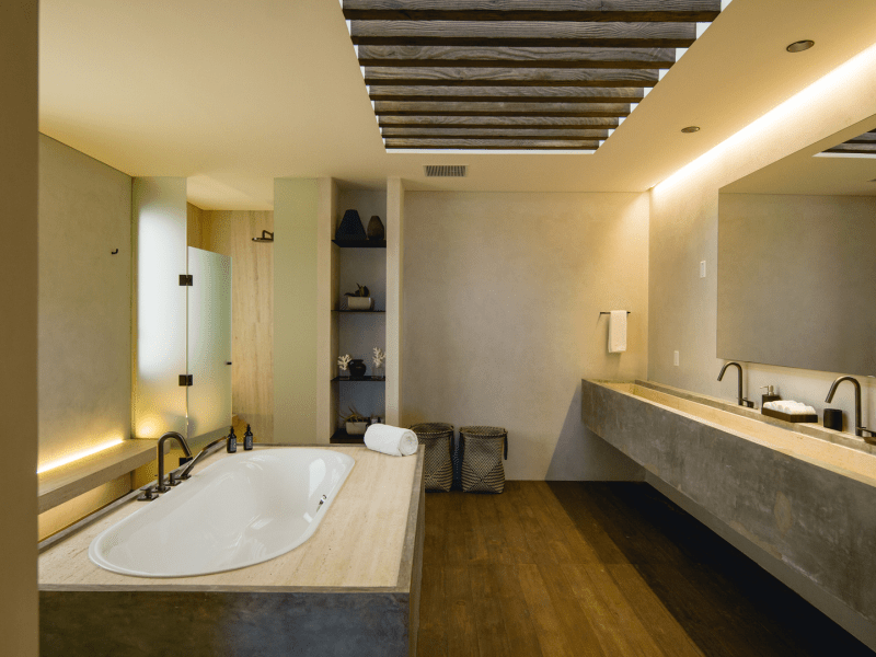 A bathroom with a long sink and large bathtub