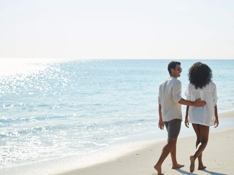 Two people walking on the beach