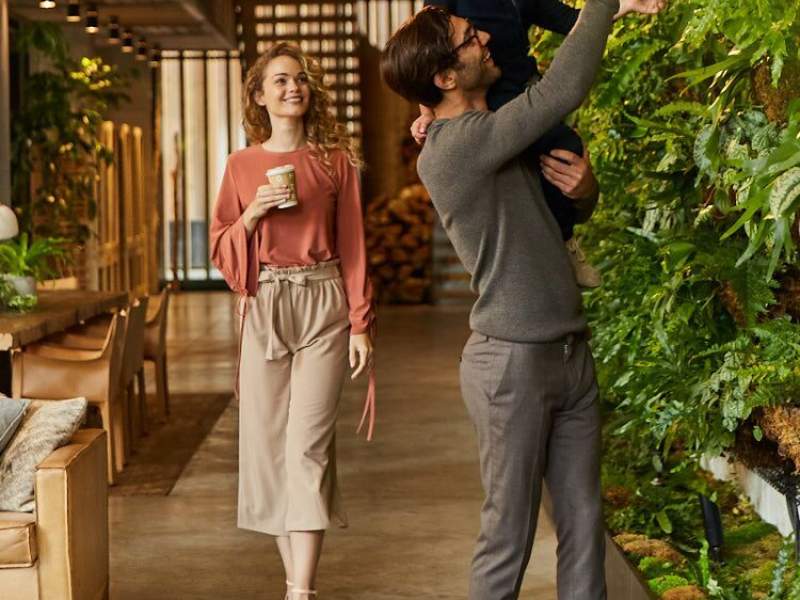 Un père brandit son fils pour regarder un mur vivant