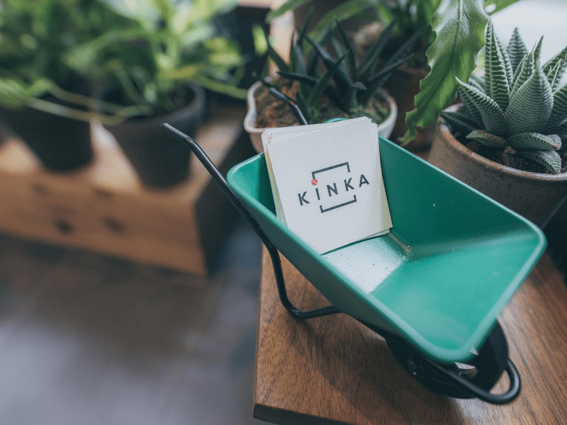 small cardholder in a pushcart shape with Kinka cards between small potted plants