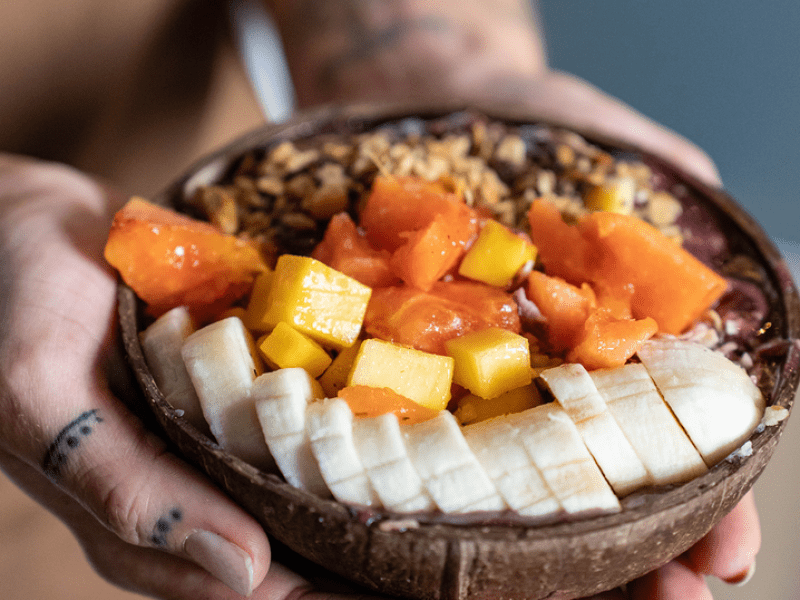 Hand handing an acai bowl